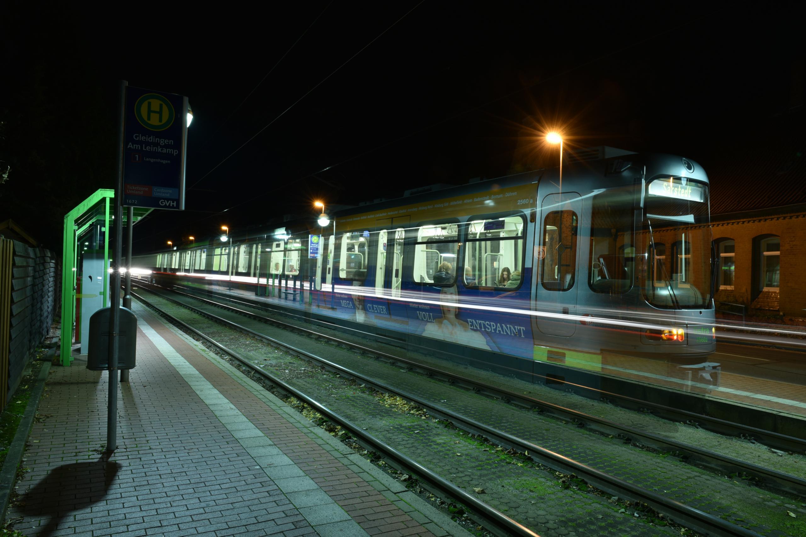 Eine Stadtbahn fährt durch die Nacht.