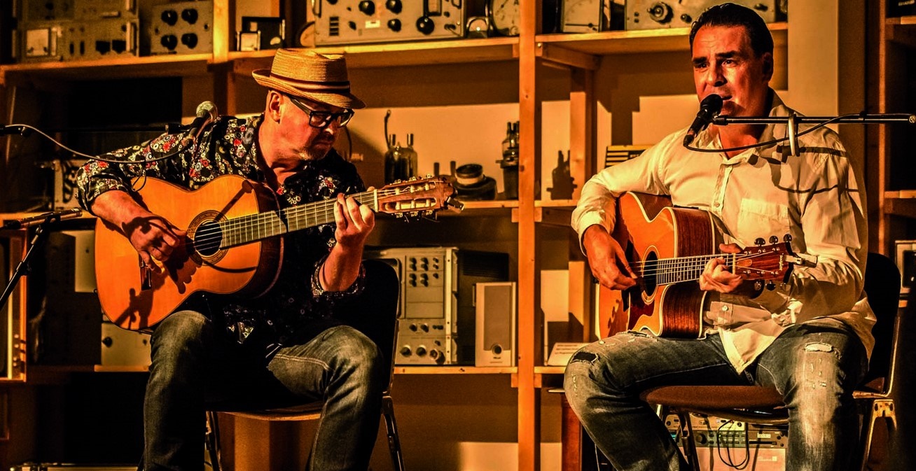 Zwei Männer singen und spielen Gitarre