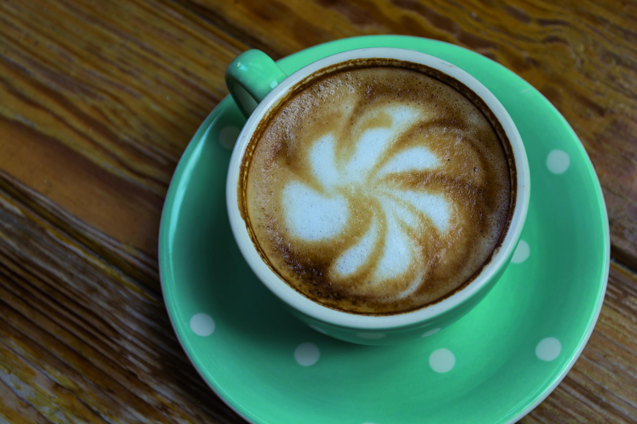 Kaffee in einer gepunkteten Tasse mit dekorativem Schaum