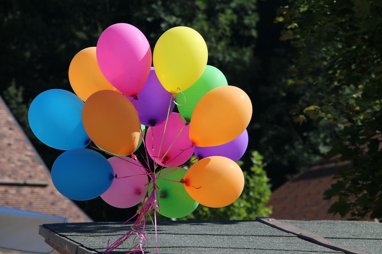 bunte Luftballons angebunden im Verbund an einem Dach