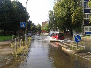 Ein Auto fährt über eine vom regen überflutete Straße in Alt-Laatzen.