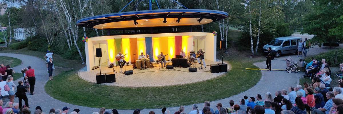 Blick von der vollbesetzten Tribüne der Kulturbühne im Park der Sinne  auf ein Konzert