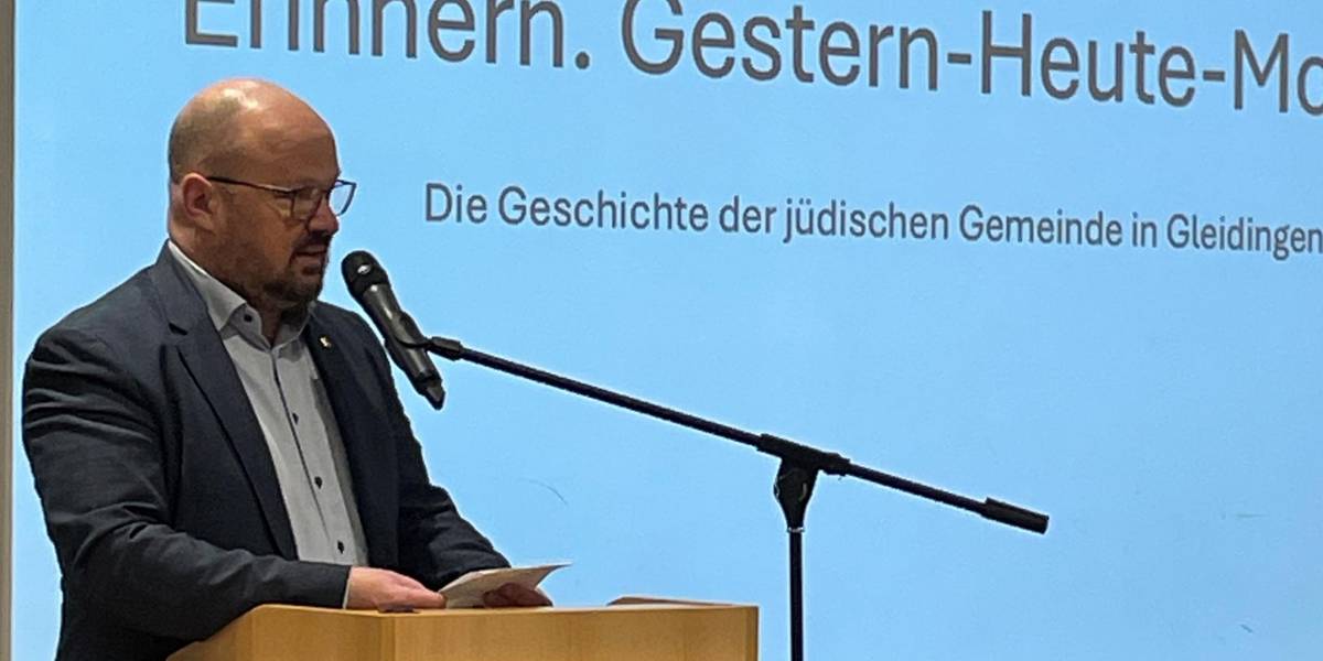 Bürgermeister Kai Eggert steht an einem Redepult, hinter ihm ist eine Präsentation an der Wand.