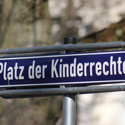 An einer Straße sieht man ein Straßenschild mit dem Titel Platz der Kinderrecht.