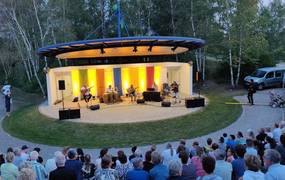 Blick von der vollbesetzten Tribüne der Kulturbühne im Park der Sinne  auf ein Konzert