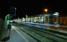 Eine Stadtbahn fährt durch die Nacht.