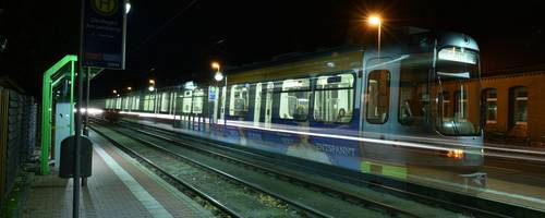 Eine Stadtbahn fährt durch die Nacht.