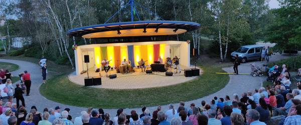 Blick von der vollbesetzten Tribüne der Kulturbühne im Park der Sinne  auf ein Konzert